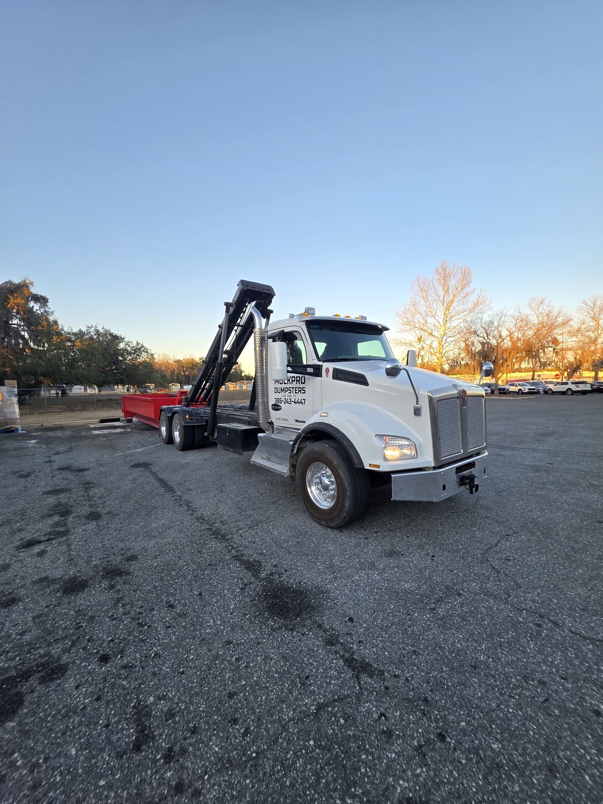 Muckpro Kenworth dropping a commercial dumpster at dawn on US 90 West in Lake City FL