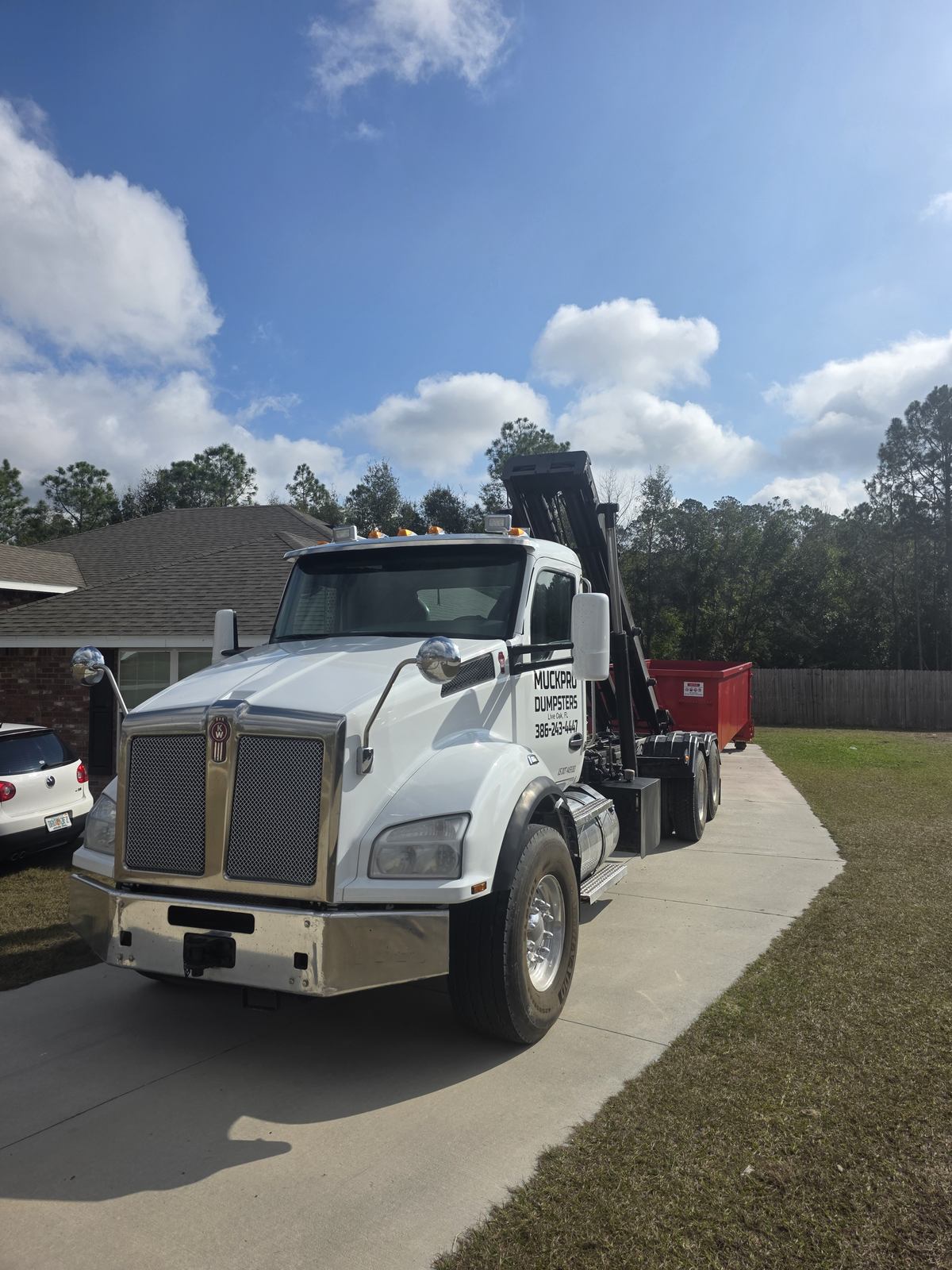 Muckpro roll-off truck delivering a dumpster to a home near Colonial Glen in Lake City, FL