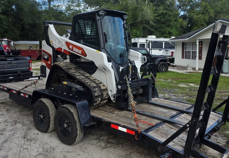 Muckpro Bobcat T66 compact track loader chained down on the delivery trailer